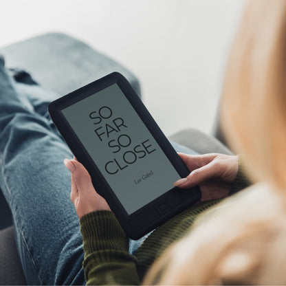 Woman relaxing and reading So Far So Close on an e-reader.